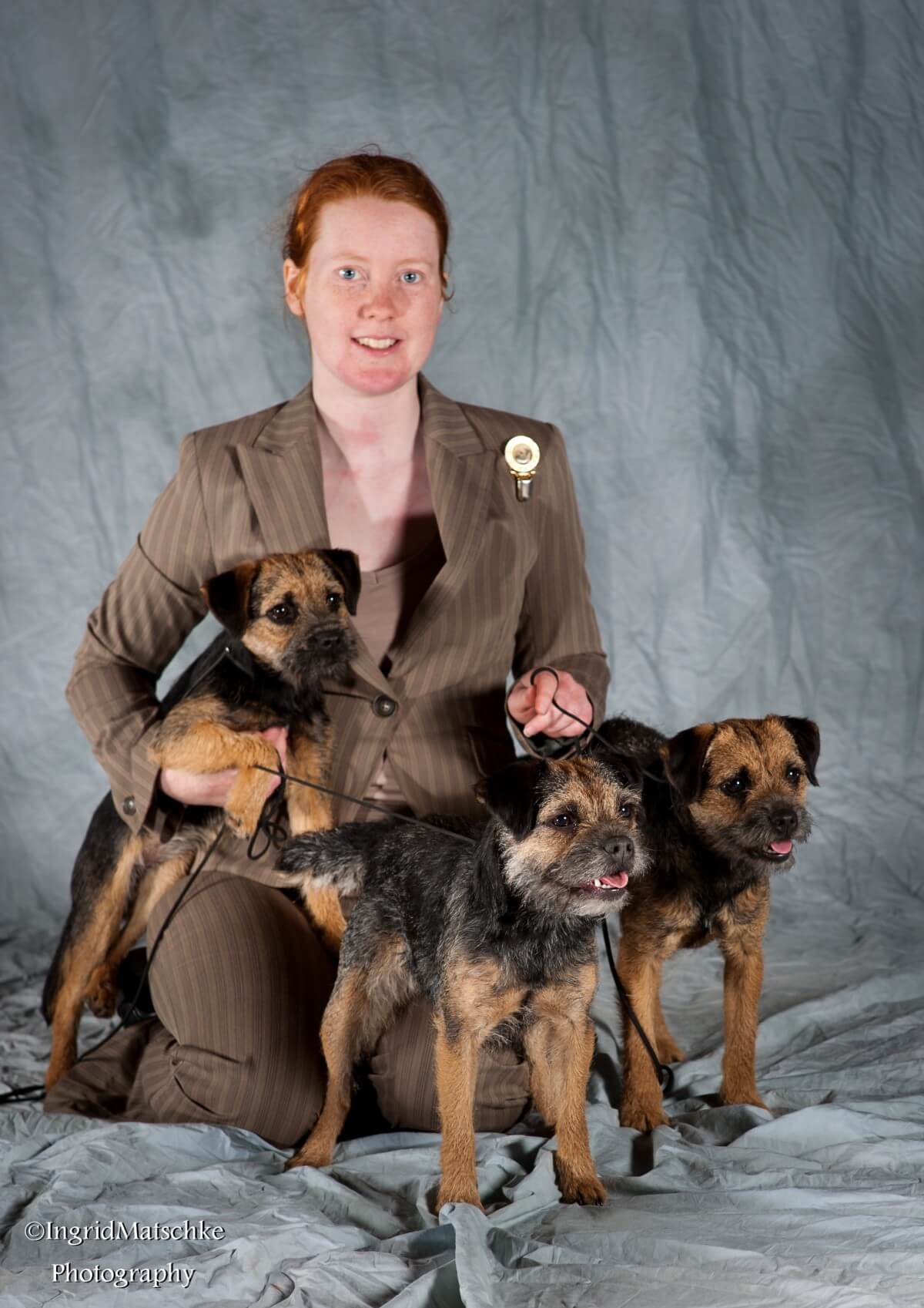 Tegan Whalan posing with a selection of her Border Terriers.